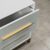 Close-up of a modern white bedside table with an open drawer, featuring elegant gold handles and a gold steel base.