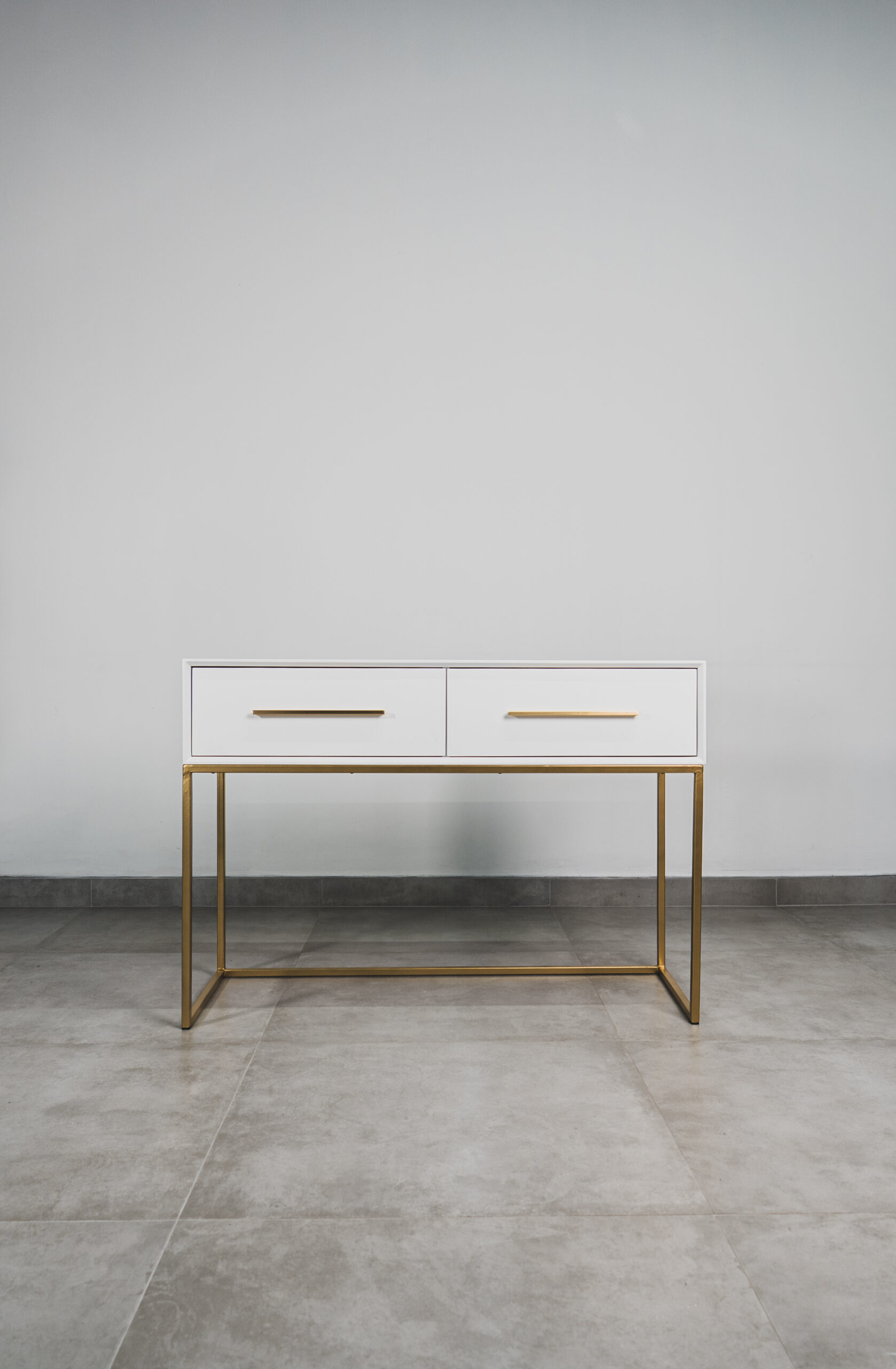 White two-drawer bedroom dressing table with gold metal frame and handles.
