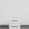 White two-tone side table with black handles and black steel base, featuring a modern minimalist design.