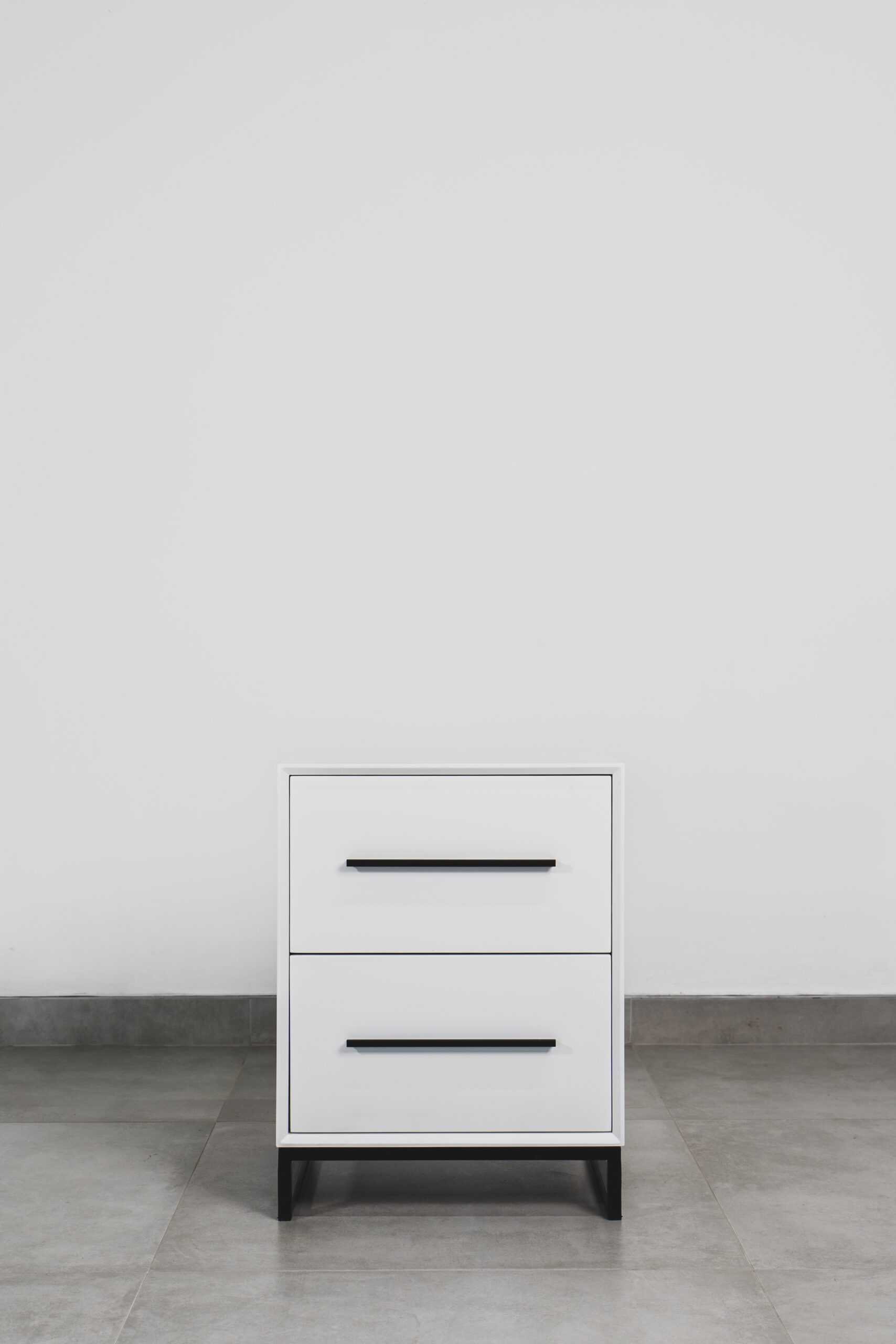 White two-tone side table with black handles and black steel base, featuring a modern minimalist design.
