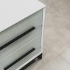 Close-up of a modern white two-tone side table with black handles and a black steel base, highlighting its sleek minimalist finish.