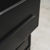 Close-up of a modern black pedestal with one drawer slightly open, showcasing sleek black handles and a smooth matte finish.
