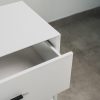 Close-up of a white 3 drawer chest of drawers with one drawer partially open, featuring black handles and a steel base.