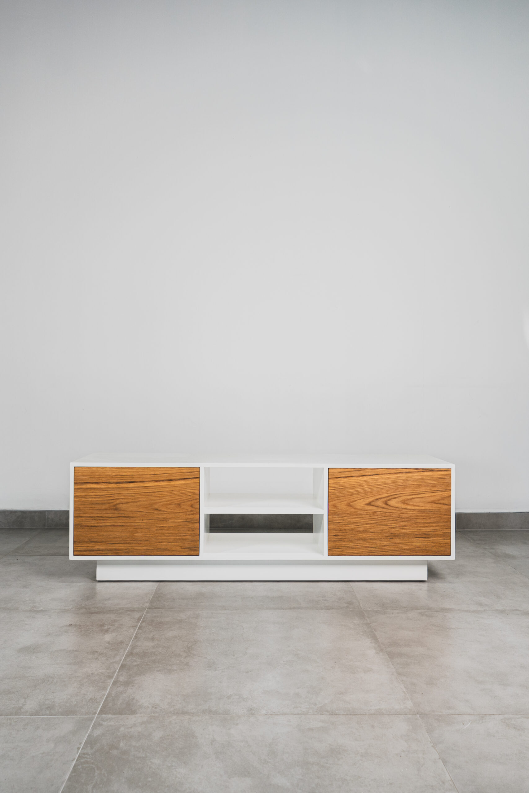 Modern Scandinavian white TV stand with natural wood doors and open middle shelving, featuring a clean minimalist design and floating base.
