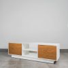 Scandinavian white TV stand with natural wood doors, open centre shelves, and floating base for a modern minimalist living room.