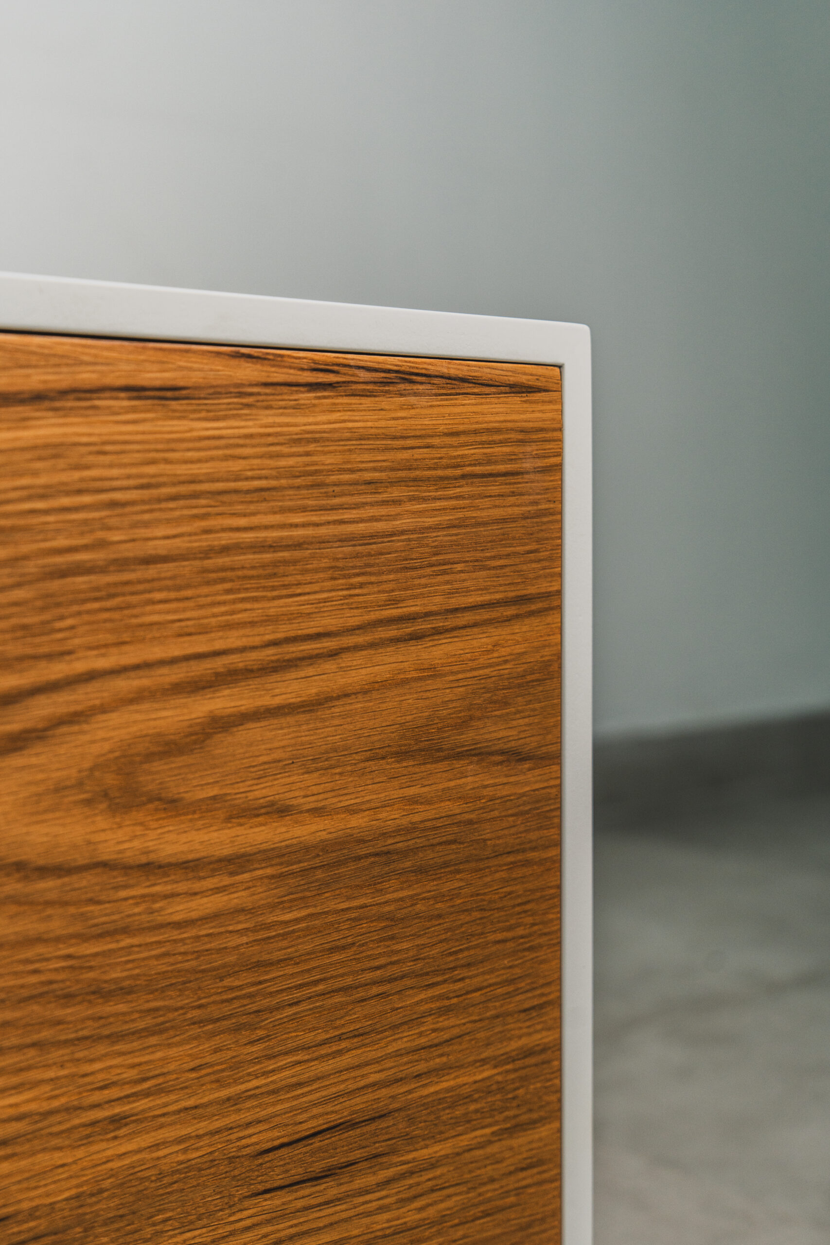 Detail close-up of Scandinavian white TV unit featuring natural wood grain cabinet door, highlighting clean craftsmanship and minimalist style.