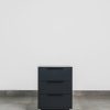 Front view of a dark grey three-drawer pedestal with a matte finish and minimalist modern design.