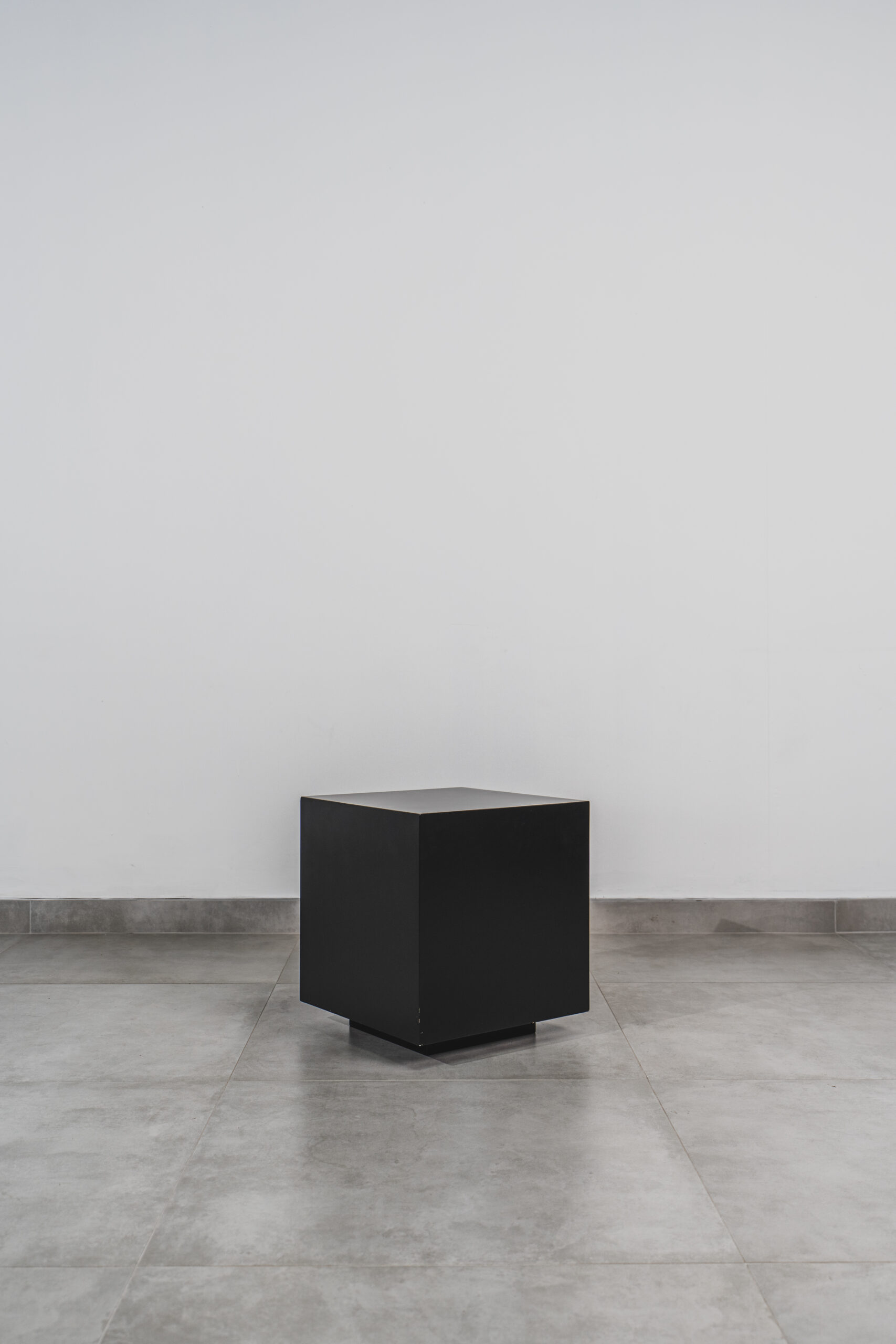 Modern black cube side table with a sleek, minimalist design, perfect for contemporary interiors or small spaces.