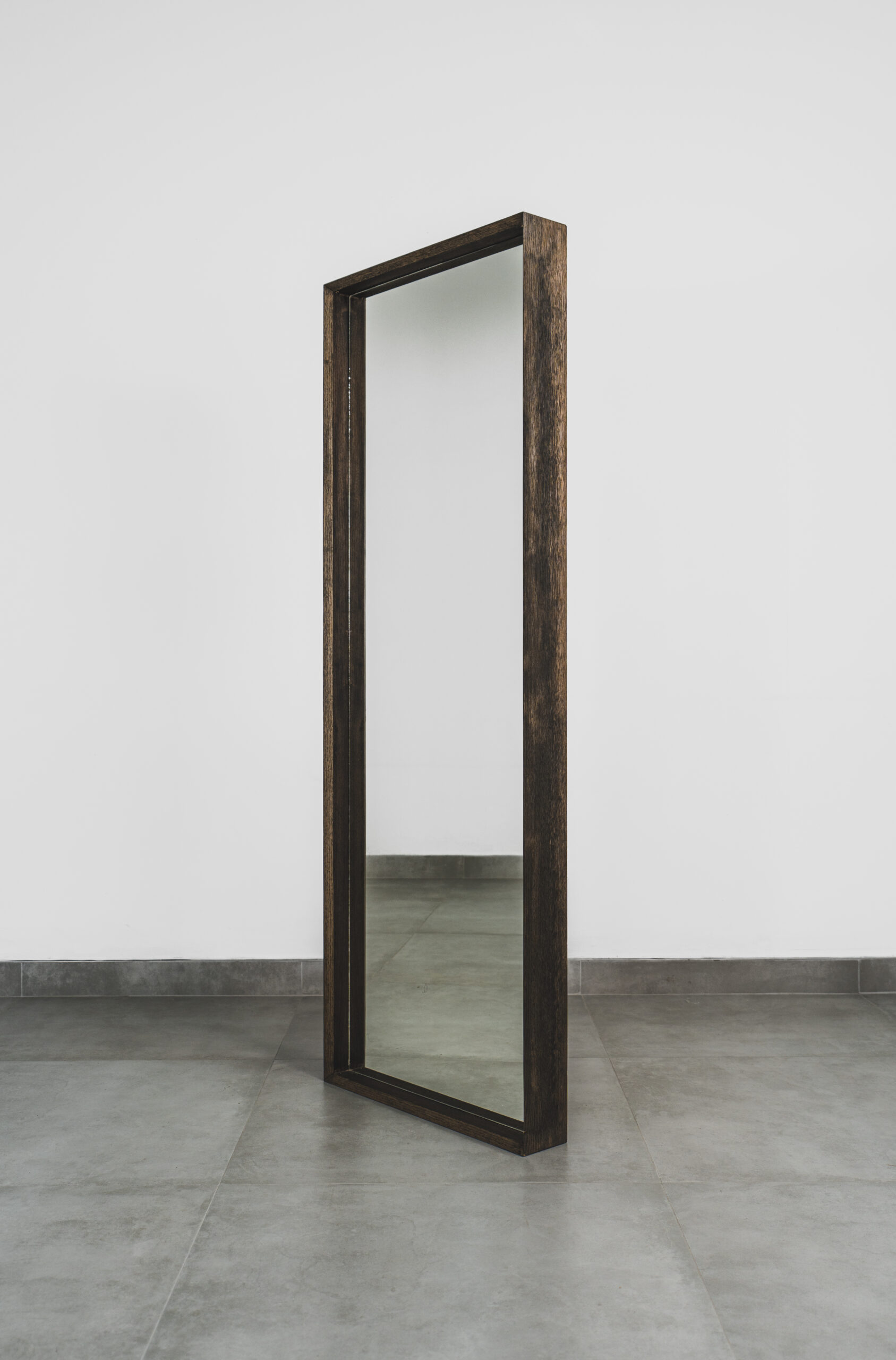 Large standing mirror with dark wood frame, free-standing full-length mirror ideal for bedrooms, dressing rooms, or modern interiors.