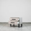 Two-drawer modern pedestal with a soft grey-beige finish and minimalist metal legs.